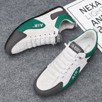 White sneakers with green and black accents on a gray surface