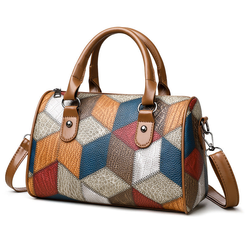 Multicolored patchwork handbag with brown handles and strap on a white background