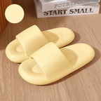 Pair of yellow slippers on a wooden surface with a book titled 'Start Small' in the background.