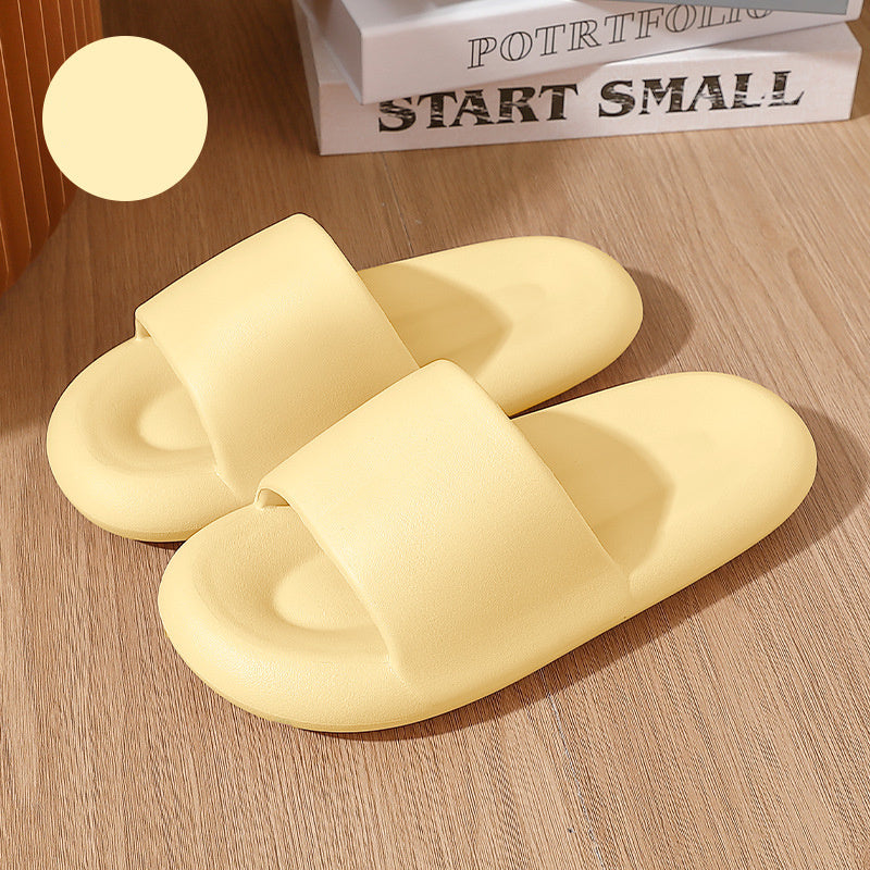 Pair of yellow slippers on a wooden surface with a book titled 'Start Small' in the background.