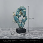 Abstract sculpture of two faces on a gray background with dimensions indicated.