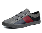 Gray and red sneaker with velcro straps on a white background