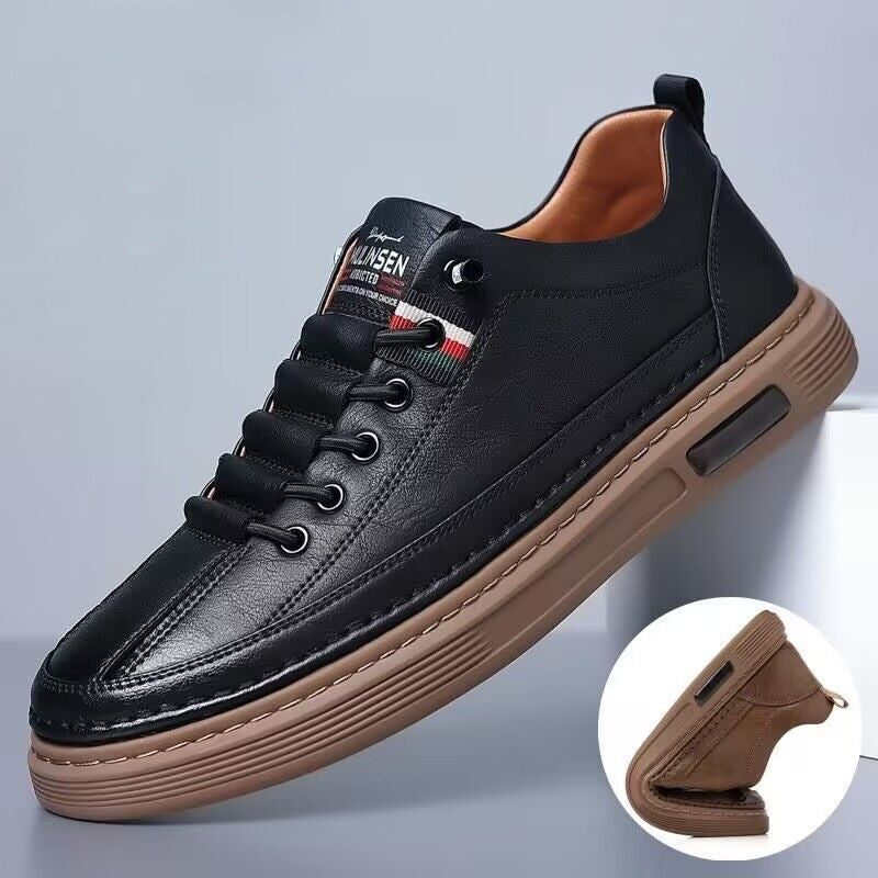 Black leather sneaker with brown sole on a gray background