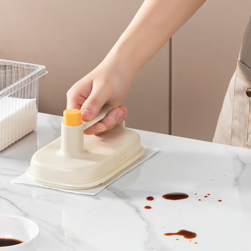 Person using a white suction cup with a yellow center on a marble surface.