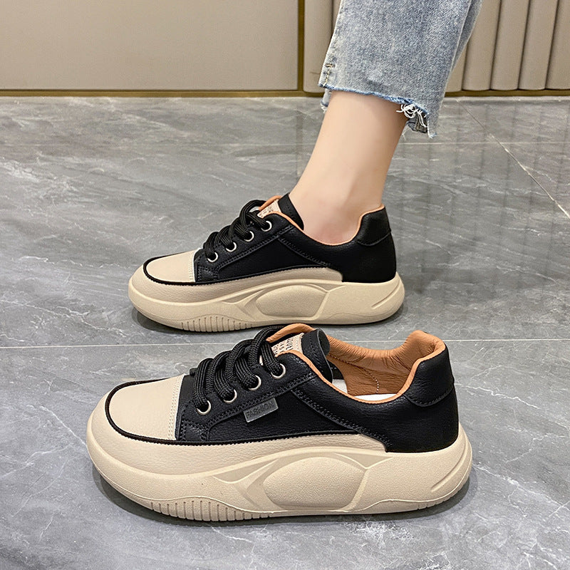 Black and beige sneakers on a gray floor
