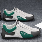 White sneakers with green and black accents on a gray surface