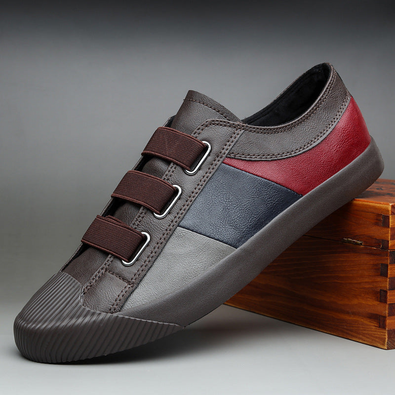 Multicolored sneaker with brown, red, and blue sections on a gray background