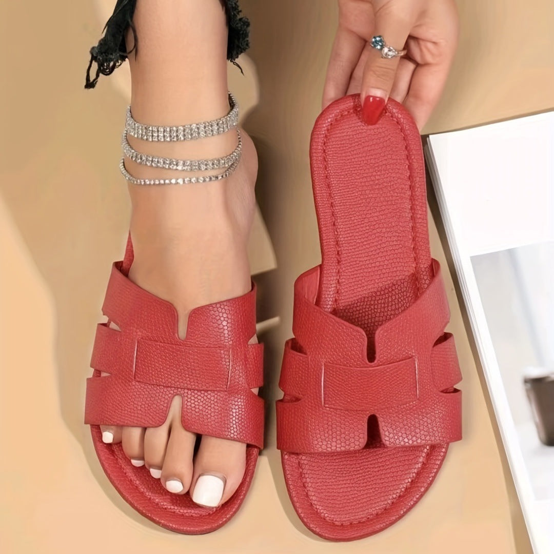 Red sandals being worn with a neutral background