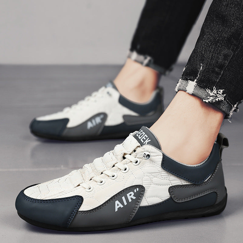 White and black sneakers with 'Air' branding worn by a person on a gray floor.
