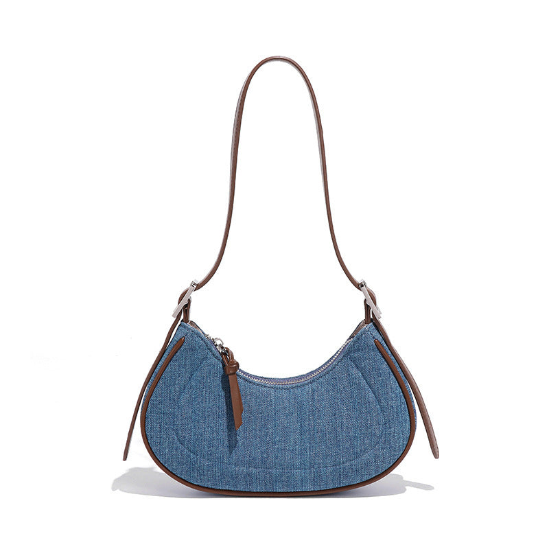 Blue denim handbag with brown leather accents on a white background
