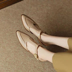 Beige loafers worn by a person on a textured surface