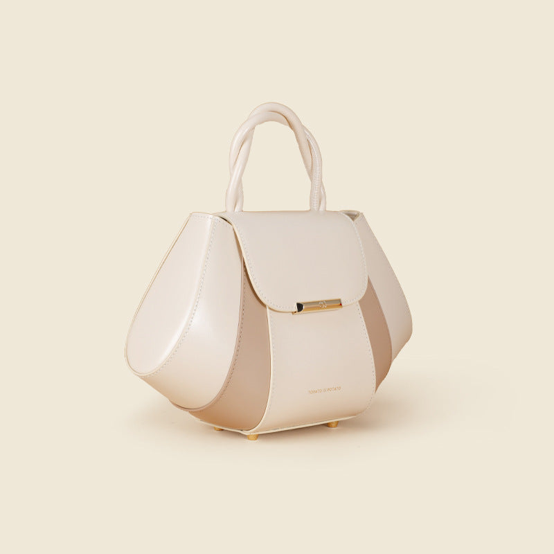 White handbag with gold accents on a beige background