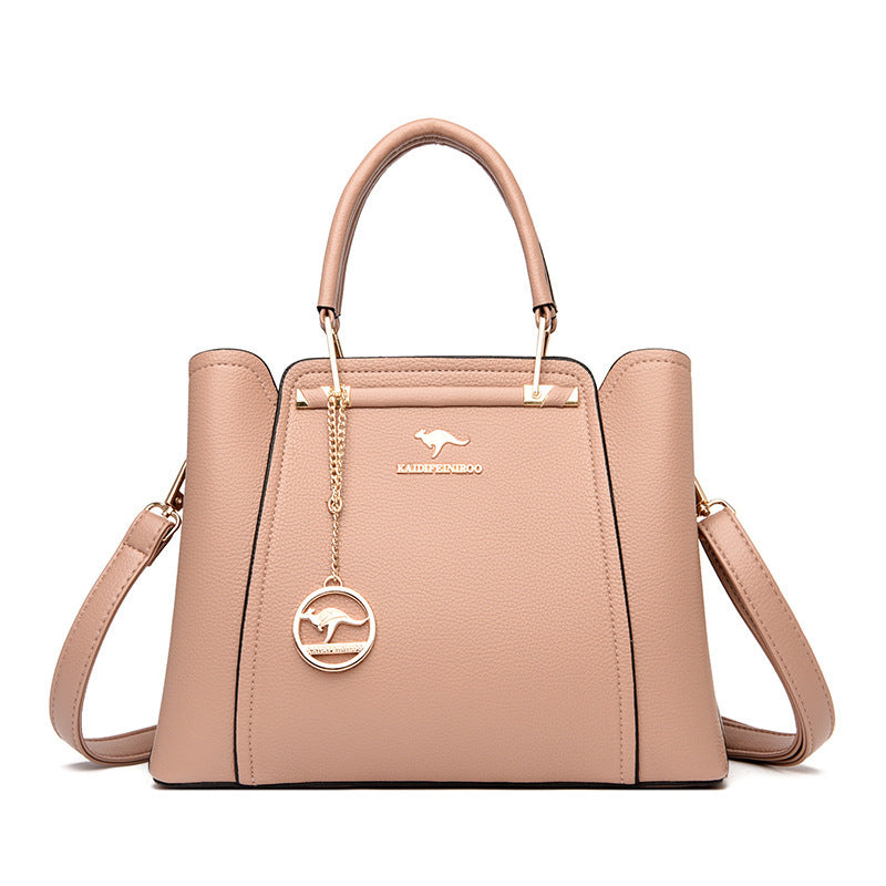 Beige handbag with a gold chain and kangaroo logo on a white background