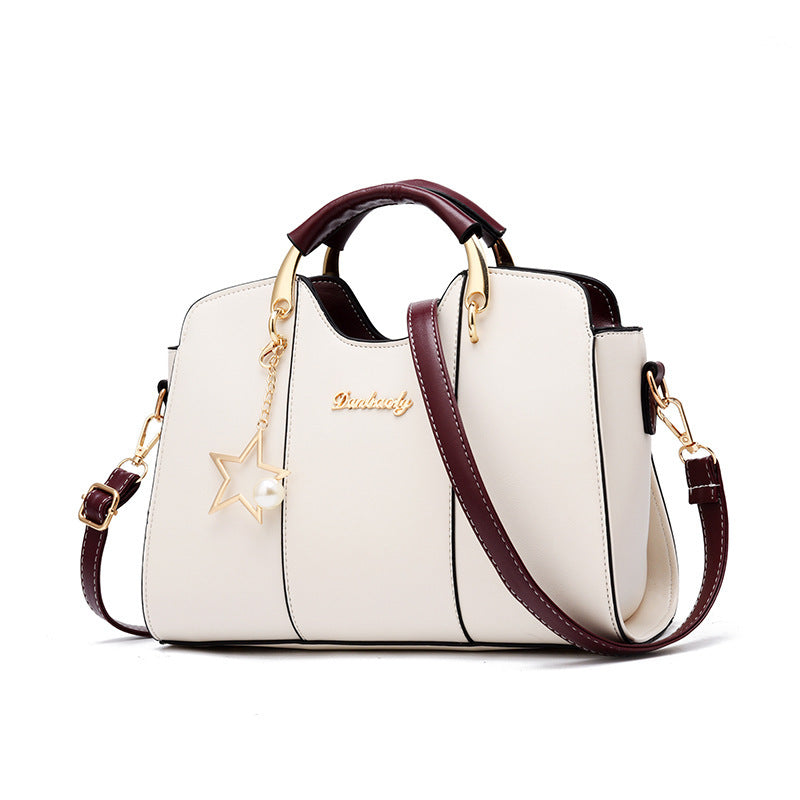 White handbag with burgundy accents and gold details on a white background