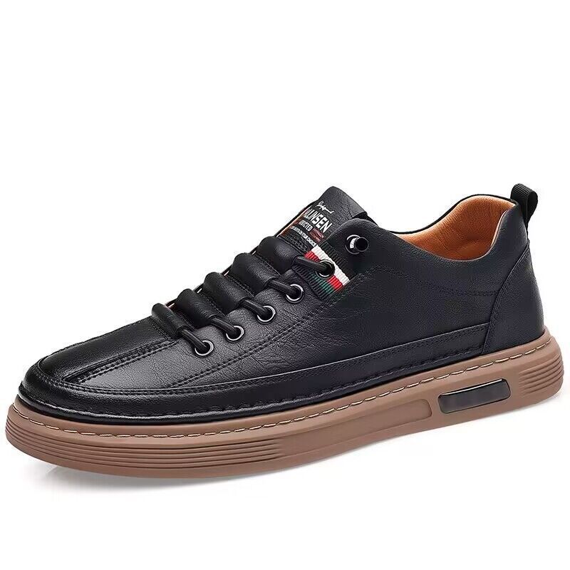 Black leather sneaker with brown sole on a white background