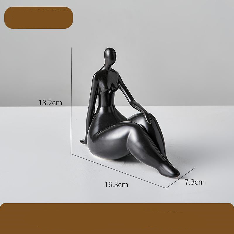 Black sculpture of a seated figure with dimensions on a gray background