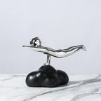 Decorative object with black base and silver top on a marble surface
