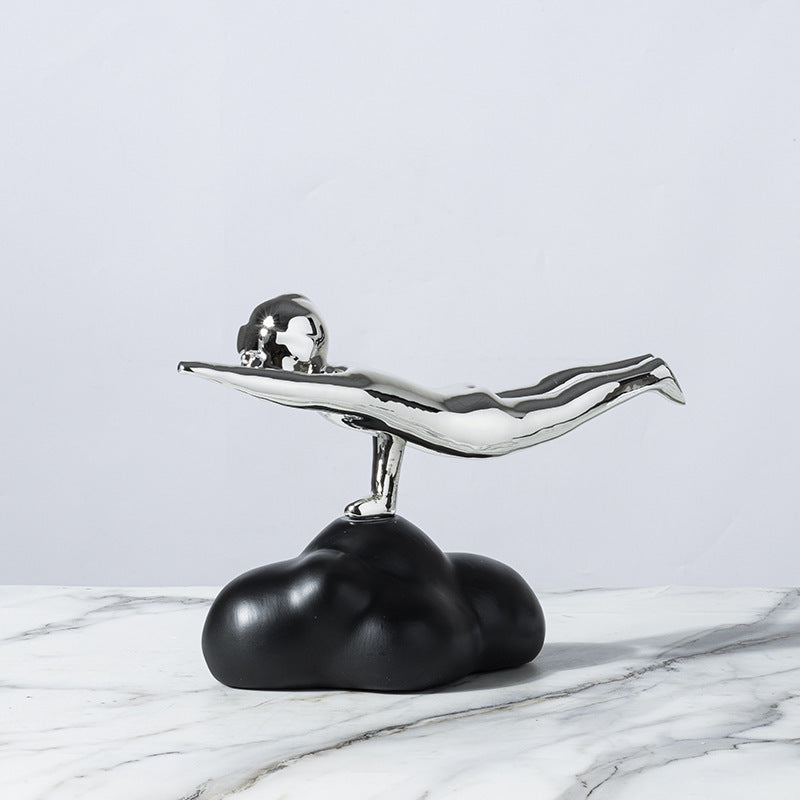 Decorative object with black base and silver top on a marble surface