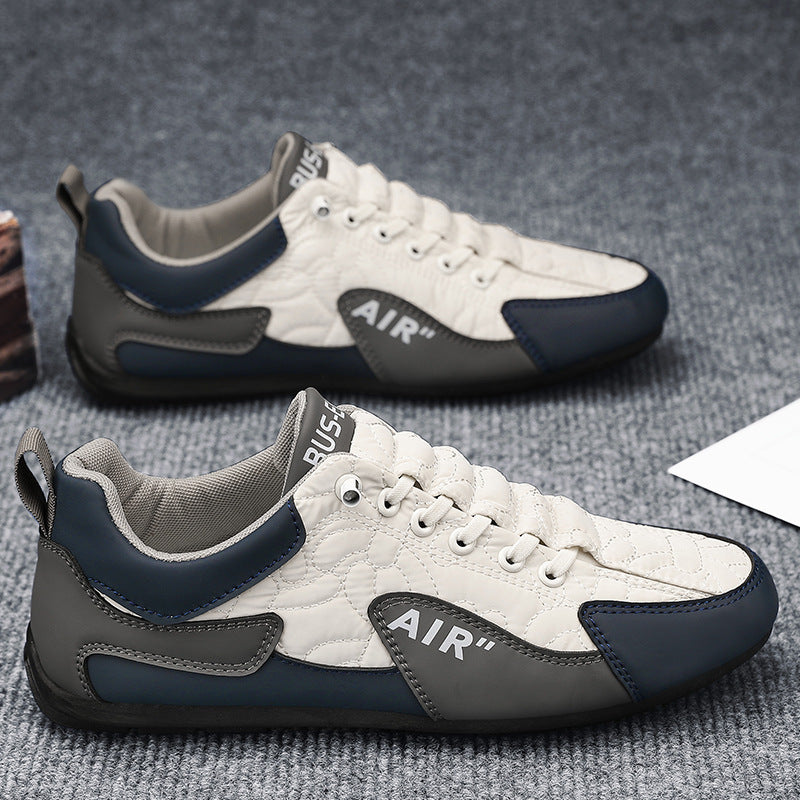 White and gray sneakers with blue accents on a textured surface