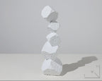 Stack of white stone sculptures on a light gray background