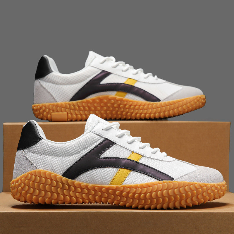 White sneakers with black and yellow accents on a cardboard box
