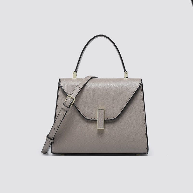 Gray handbag with a strap on a light gray background