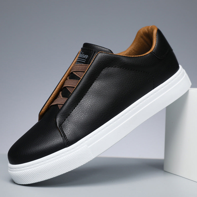 Black leather sneaker with white sole on a gray background