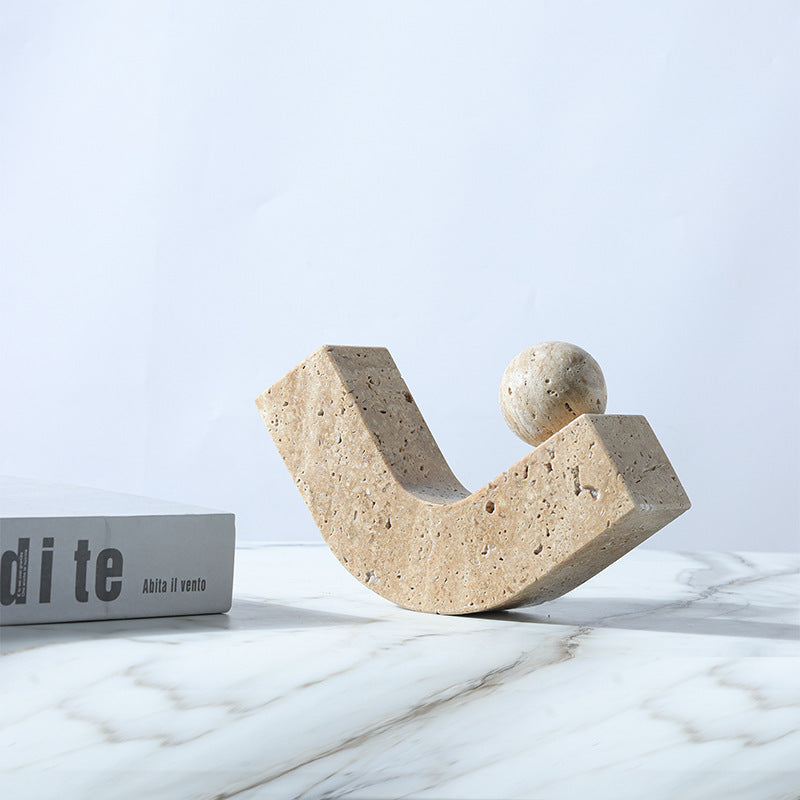 Decorative stone sculpture on a marble surface with a light blue background