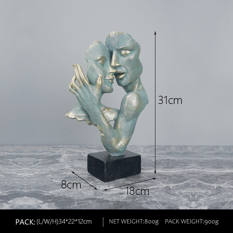 Abstract sculpture of two faces on a gray surface with measurements indicated.