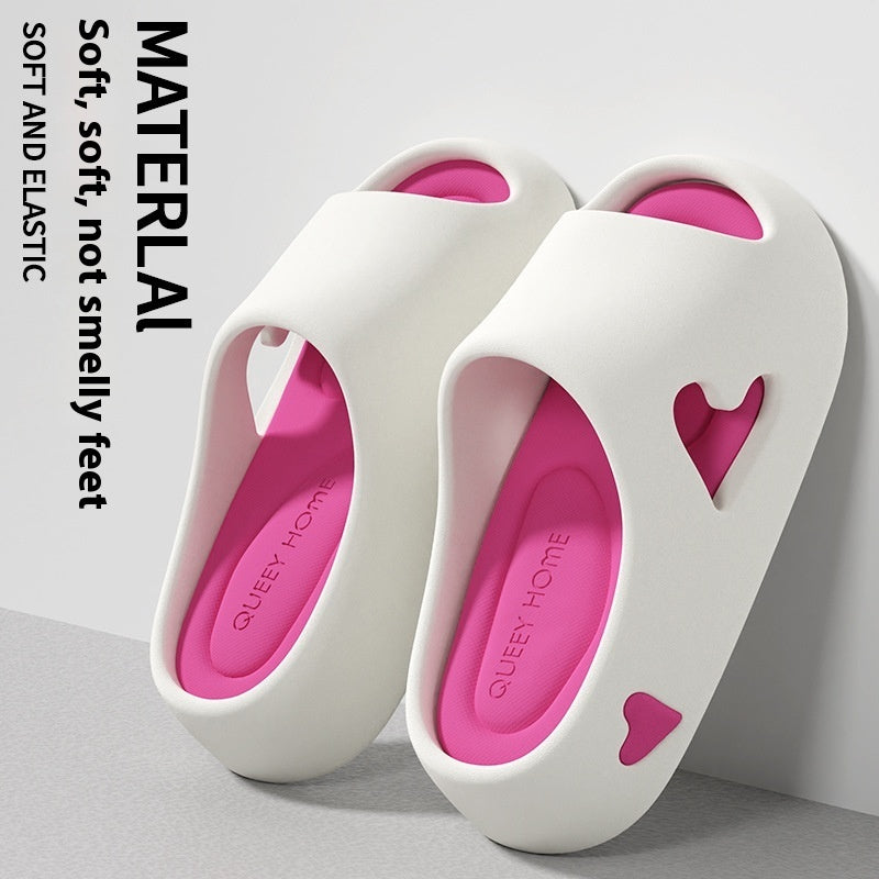 White slippers with pink hearts on a light gray background