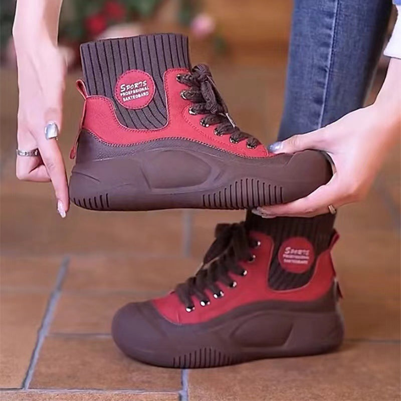 Brown and red boots held by a person on a tiled floor
