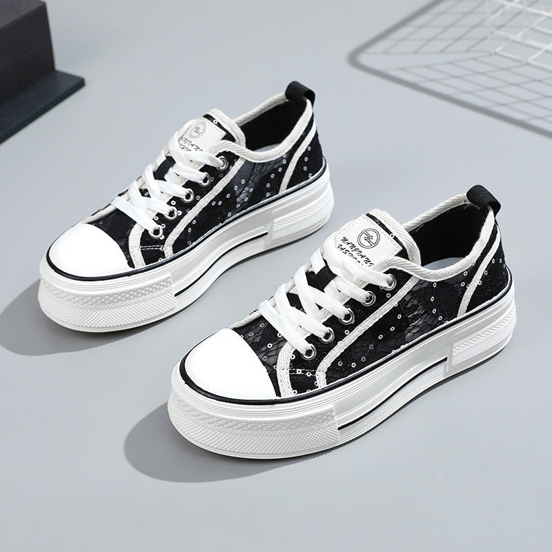 Black and white sneakers with sequin details on a gray surface