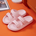 Pink sandals with buckles on an orange surface