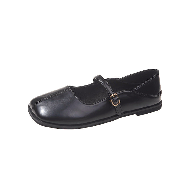 Black school shoe with a strap on a white background