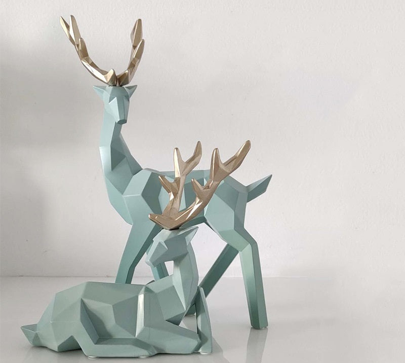 Geometric deer sculptures with gold antlers on a light gray background