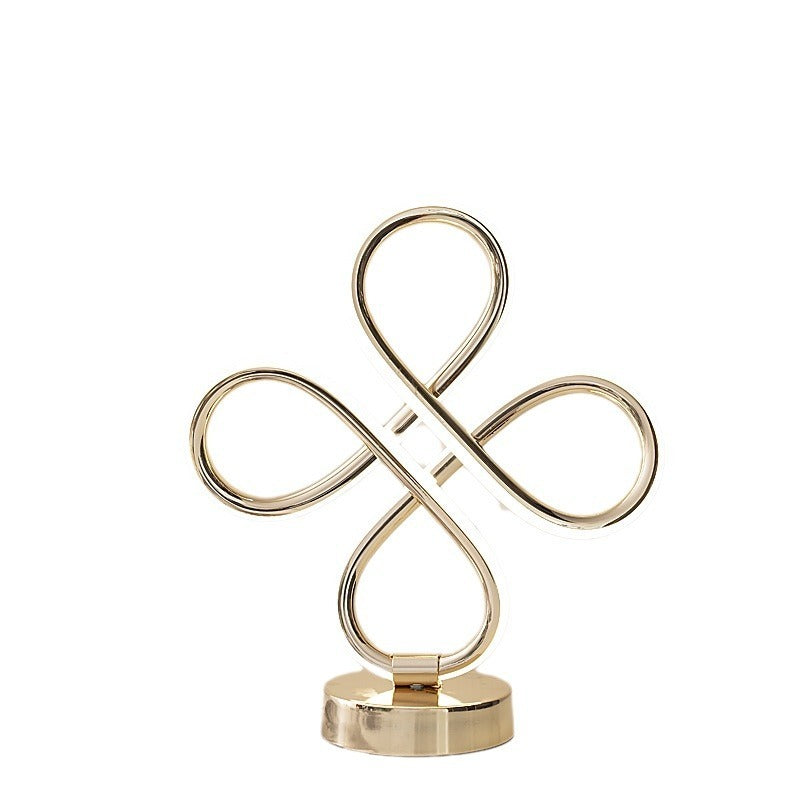 Gold decorative item with interlocking loops on a white background