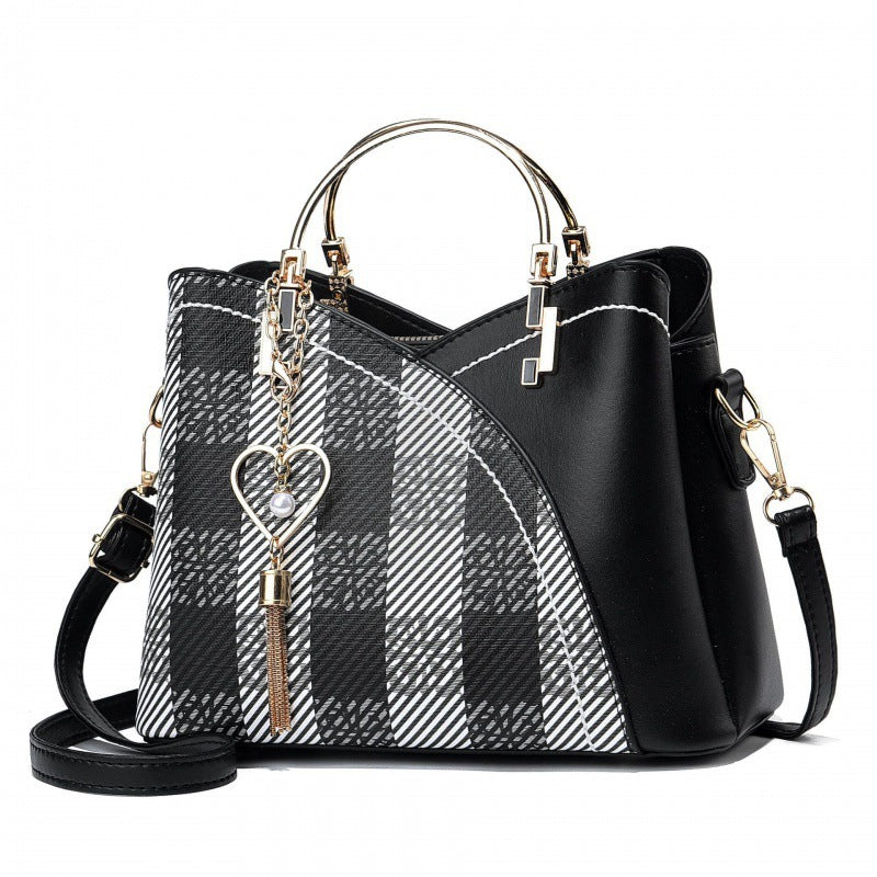 Black and white plaid handbag with gold accents on a white background