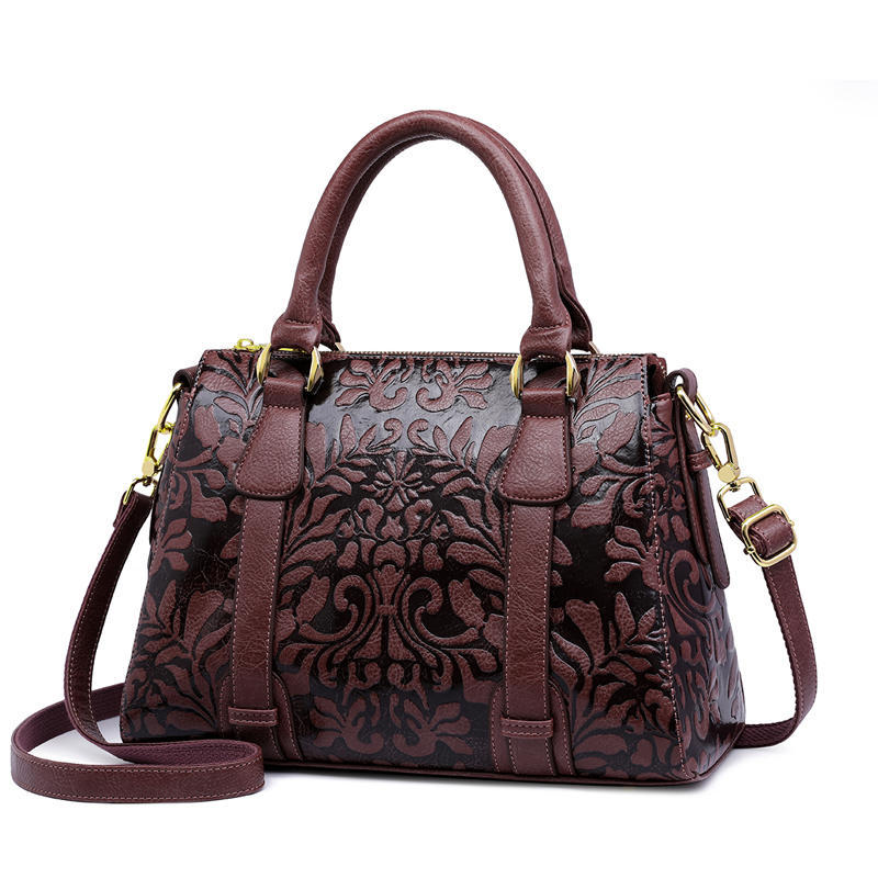 Brown leather handbag with floral patterns on a white background