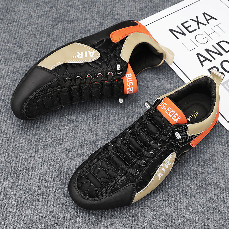 Black and orange sneakers on a gray surface with a newspaper in the background