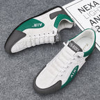 White sneakers with green and black accents on a gray surface