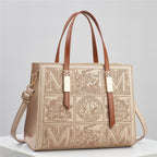Designer handbag with intricate patterns and gold accents on a light gray background
