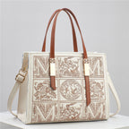 Designer handbag with intricate patterns and brown straps on a light gray background
