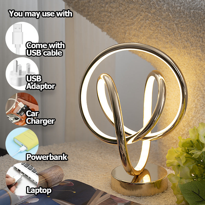 Gold decorative lamp with USB connectivity options on a blurred background