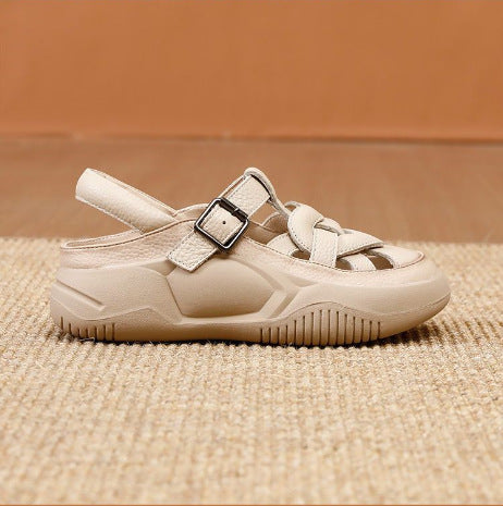 Beige sandal with a buckle on a textured surface