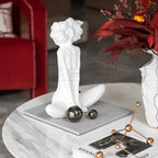 White decorative sculpture on a marble surface with a blurred background