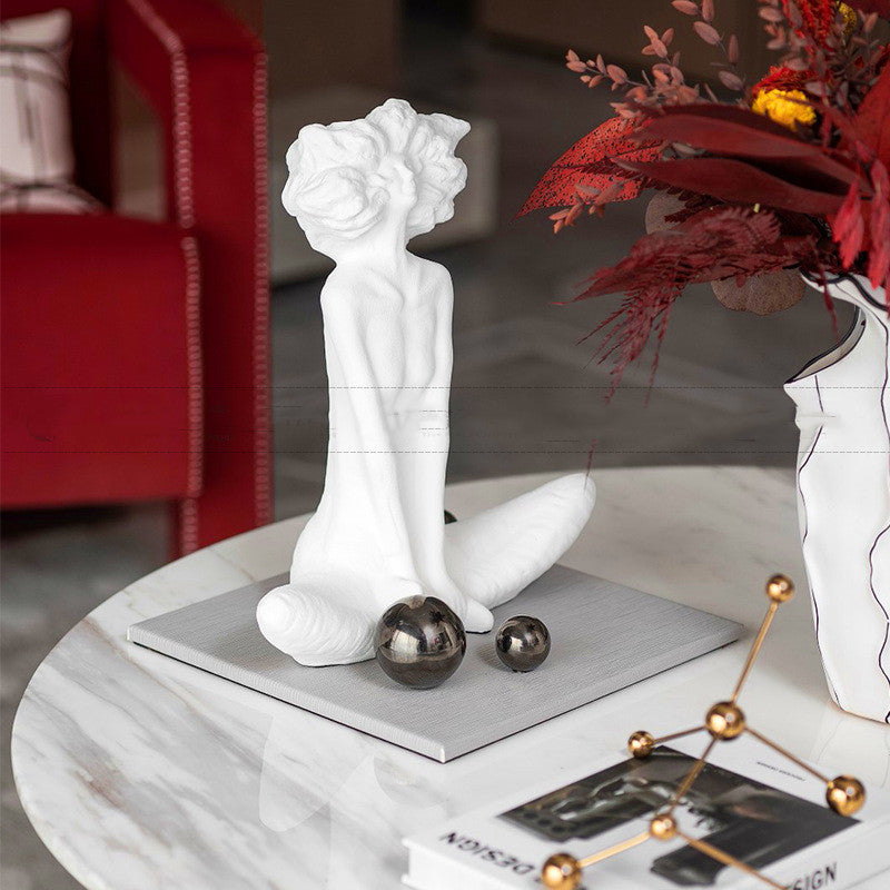 White decorative sculpture on a marble surface with a blurred background