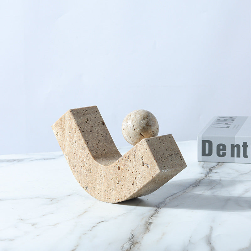 Decorative stone sculpture on a marble surface with a light blue background