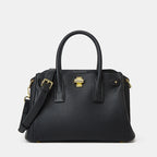 Black handbag with gold accents on a light gray background