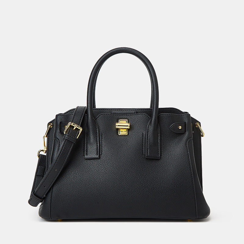Black handbag with gold accents on a light gray background