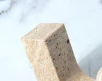Close-up of a textured stone sculpture against a blurred natural background